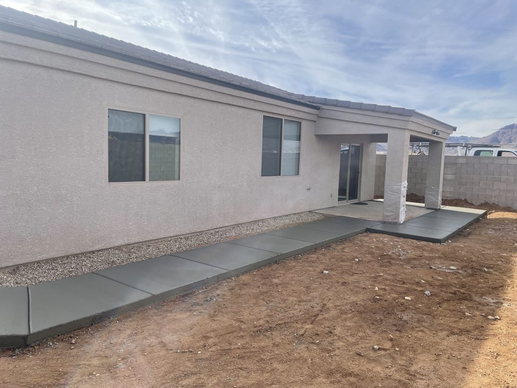 Concrete sidewalk and patio addition poured around a home in Kingman, Arizona.