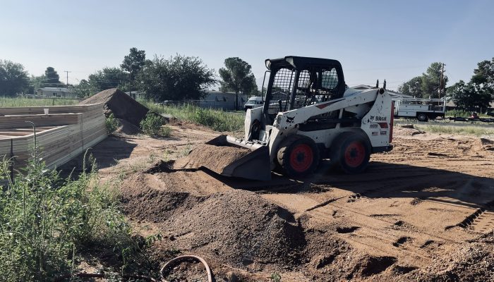 Grading out a flat pad to get ready to build on.